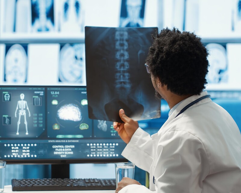 physician-reviewing-mri-scan-x-ray-results-with-patient-medical-office